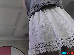 Auburn-haired gal shows off g-string in candid upskirts