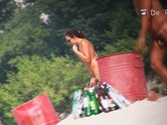 Beach nudist couple having sex in water on cam