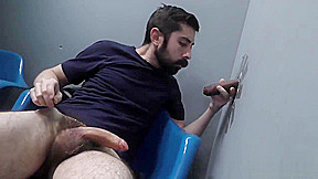 Bearded white man sucking and fucking a black cock at a gloryhole