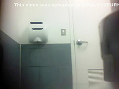 Blonde in jeans pants peeing in toilet
