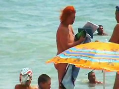 Buxom nude beach babes flaunt their jugs before a