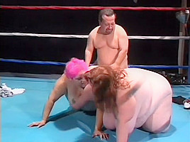Chubby ladies play with a dildo and share a midget's cock in the ring