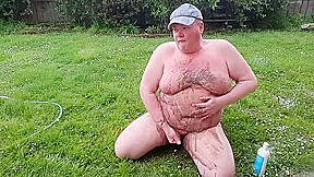 Fat man has muddy fun