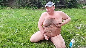 Fat man has muddy fun