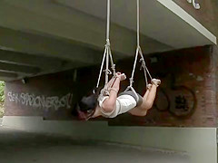 Gagged slut suspended from a bridge
