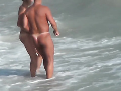   Guy with tanned ass fuck a woman at a public beach