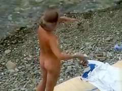 Nudist family alone on the beach relaxes all day
