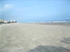 Spouse filming his wife on the beach