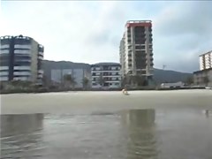 Spouse filming his wife on the beach
