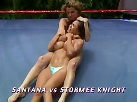 Two hot women wrestling topless in a ring