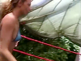 Two hot women wrestling topless in a ring