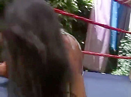 Two hot women wrestling topless in a ring